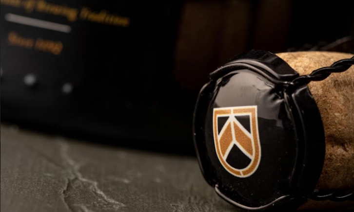 OMER Brut Nature kurk met muselet op de fles liggend op tafel